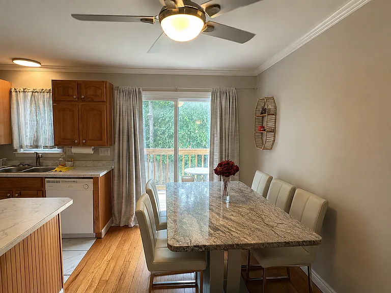 Dining area open to the kitchen, with sliding glass door to the deck
