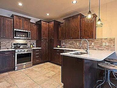 Open kitchen area, including newer stainless steel appliances.