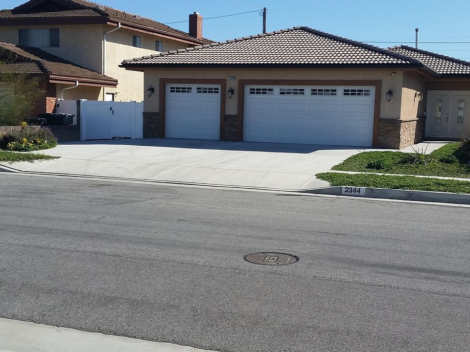 Front of the house with double door entry, drought tolerant landscape, LED Lights, side double gate from Vinyl Concepts.