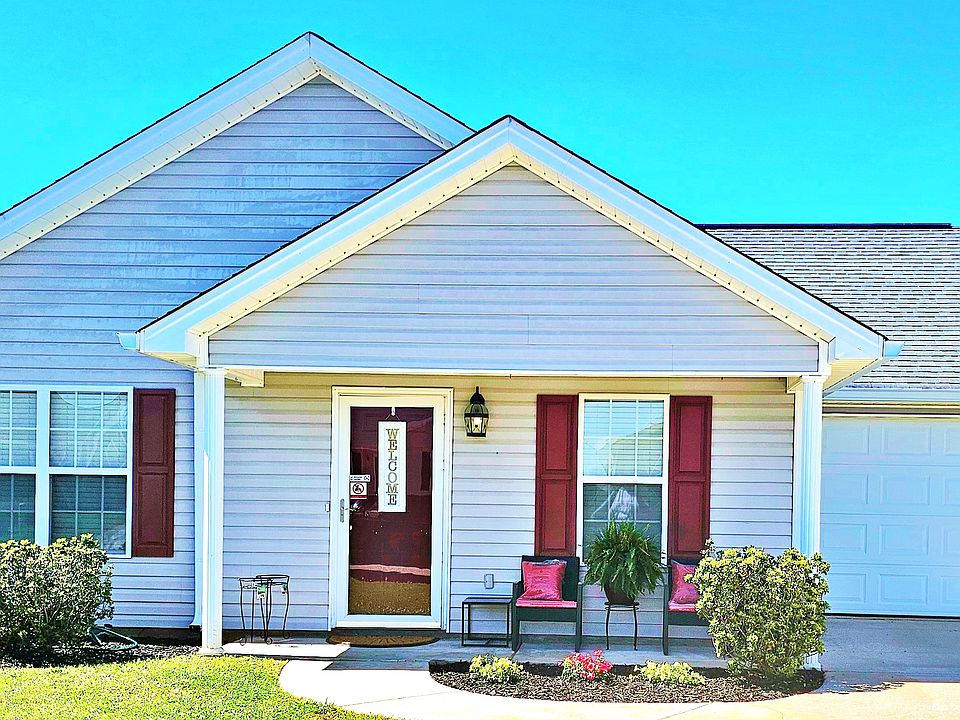 Welcome to A Southern Charm, a homey home. There is a front porch with seating and a table.