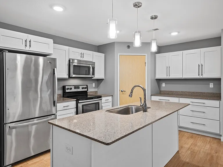 Modern kitchen design with sleek quartz countertops, stainless steel appliances, and elegant pendant lighting. Modern kitchen design with sleek quartz countertops, stainless steel appliances, and elegant pendant lighting.
