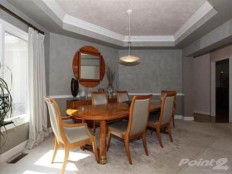 Generous dining room with trae ceiling, overhead light fixture and chair rail. Faux finish walls & ceilings.