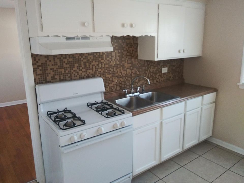 Kitchen is clean. Stove and refrigerator are white and newer. Ceramic floor.
