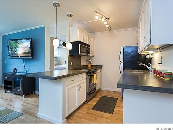 Updated kitchen with concrete counters looks into the living area for great entertaining!