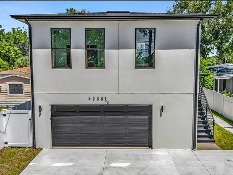 Unit is located above the garage. (Note the in-garage spaces are for the tenants of the duplex at the front of the property. Apartment tenants use the two driveway spots to the right.)