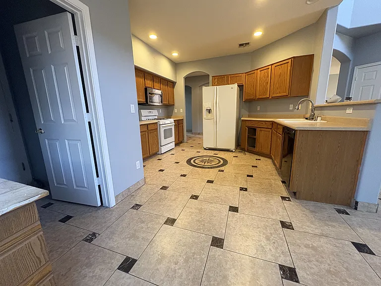 Kitchen from the breakfast nook with a washing area and garage entrance to the left
