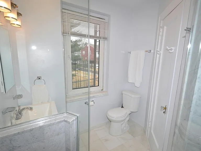 Fully renovated bath with marble tiled step-in shower.