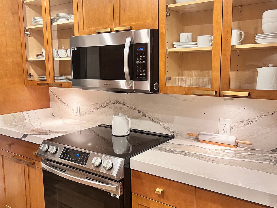 Glass-front cabinets bring allows this alleyway kitchen to feel open and inviting.