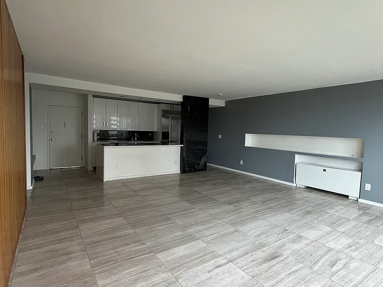 Large living room with travertine floors, beautiful wall of built-in closets, open kitchen, floor to ceiling windows- fantastic light and Mountain Views