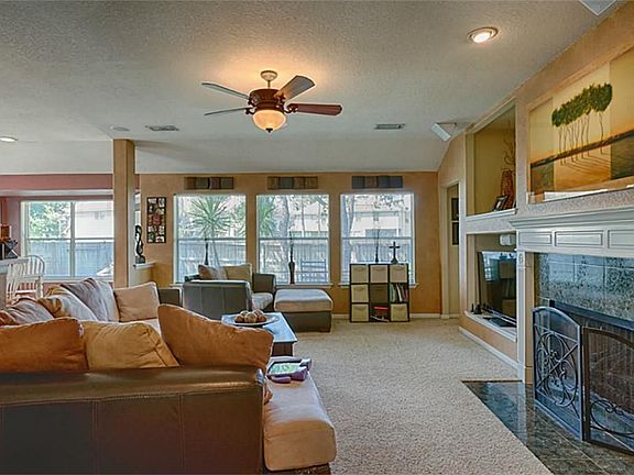 SPACIOUS FAMILY ROOM WITH FIREPLACE AND A WALL OF WINDOWS LOOKING IN TO THE BACK YARD