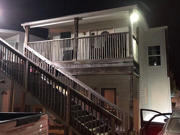 Rear of building with view of back stairwell with covered porch.