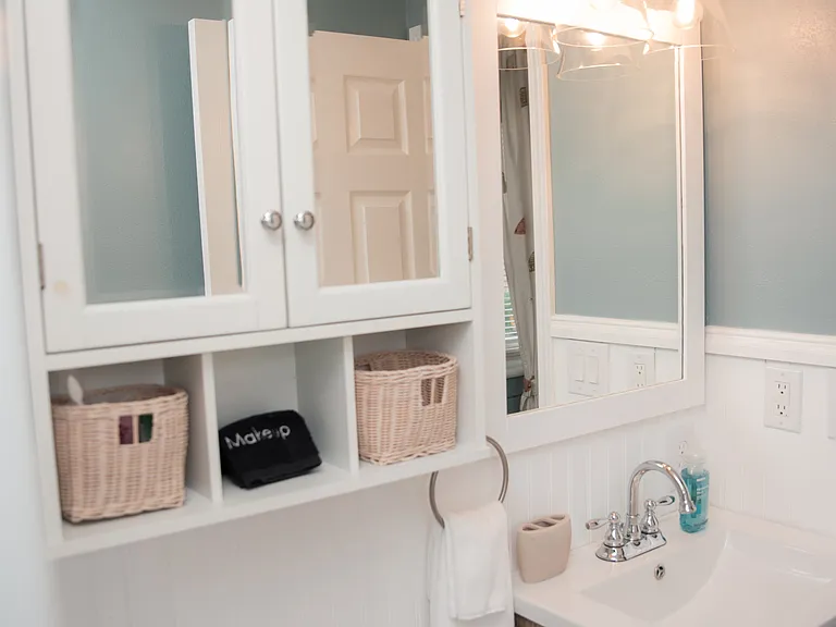 Bright vanity area with a wood-toned cabinet and extra storage for your toiletries.