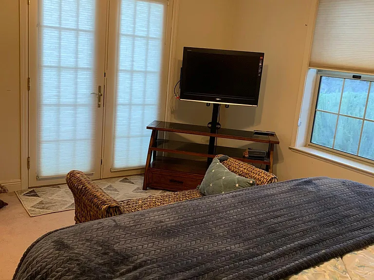 Fully furnished main bedroom with full bathroom, and french doors that walk out to a garden, large deck, with lounge chair, large table that seats five outdoor lunch, dinner, or relaxing with a great book, tanning, working out, the list is endless:-))