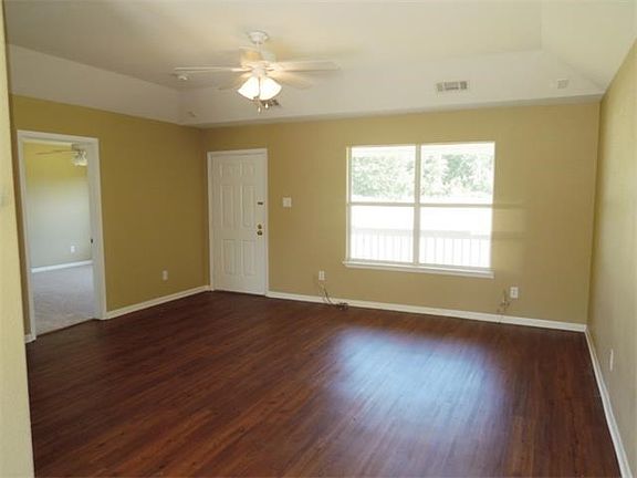 Another view of the living room looking towards the front door. Guest bedroom on left, master on right