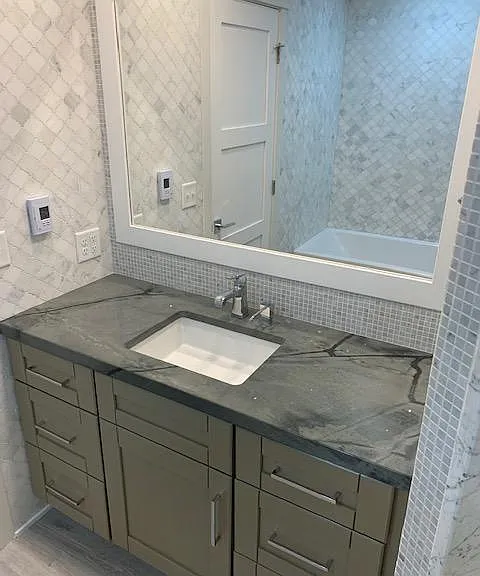 Main level bathroom vanity and tiling. Has both shower and tub.