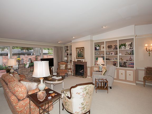 Living/dining area w/wall of windows overlooking patio