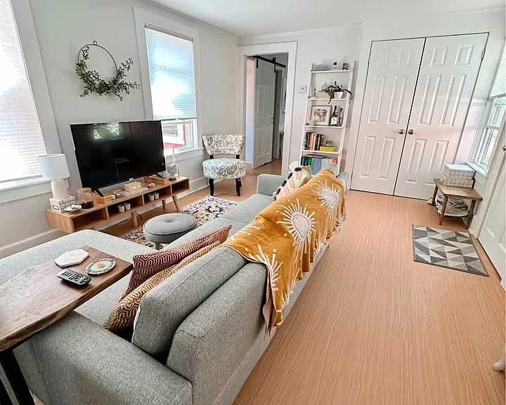 There is a double closet for supplies and coats in the living room. The open door way leads to the kitchen. There are three windows in this room making it bright.