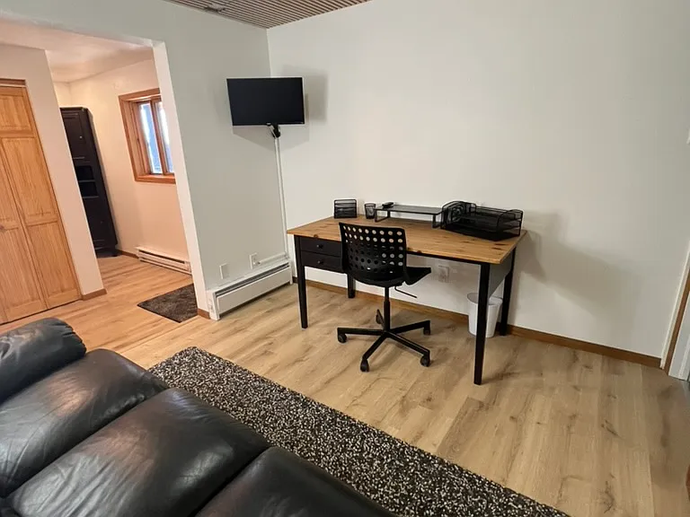 Den/office with 24" Smart TV; desk and office accessories (view toward private entry door)