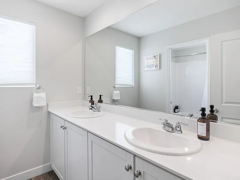 Full Bathroom 2 is located upstairs right next to Bedroom 2 and features a bathtub shower combo with double vanity sinks and toilet.