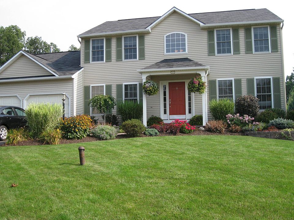 Curb appeal at its finest w/ new driveway, stone wall & perennial landscaping