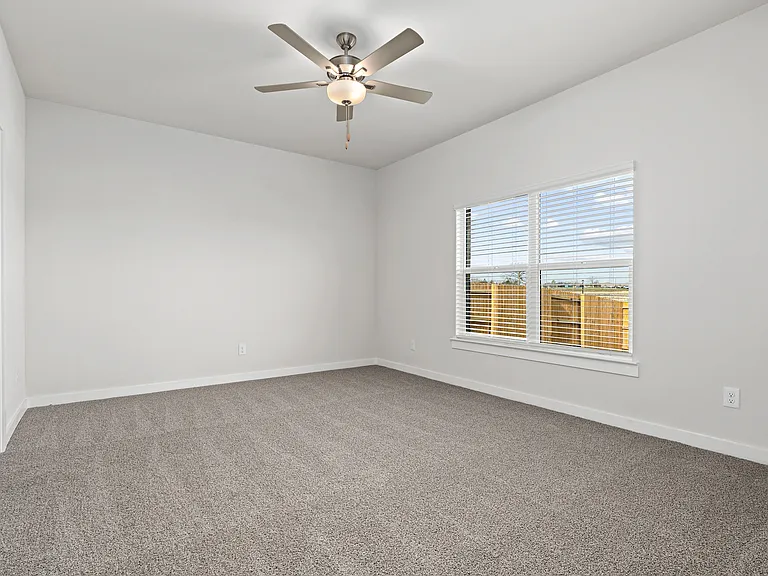 The spacious master bedroom has a window that lets in great, natural light and backyard views.