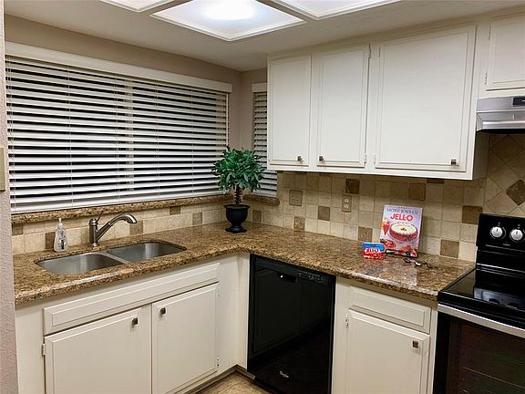 UPDATED KITCHEN WITH GRANITE COUNTERTOPS, TILE BACKSPLASH, TILE FLOORING AND FAUX WOOD BLINDS....ADORABLE!