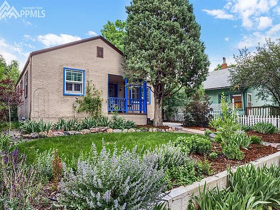 Front of home with flower beds and stucco exterior