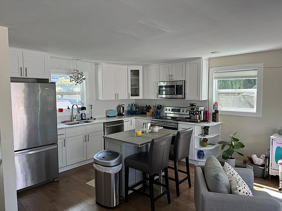 Newly renovated kitchen with natural stone countertops and stainless steel appliances including a dishwasher.