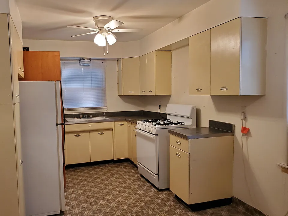 Kitchen with lots of cabinets, gas range and refrigerator.