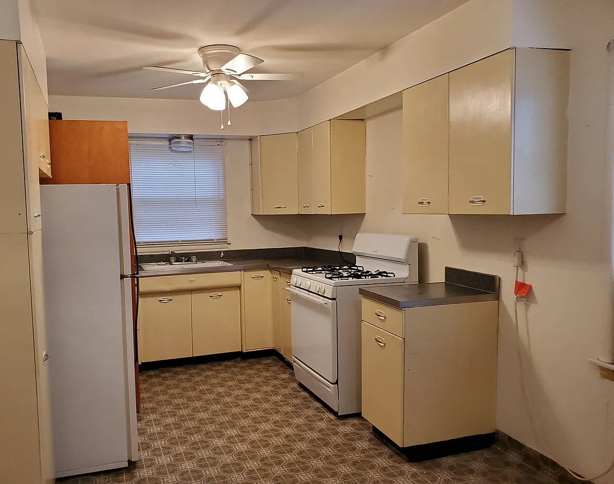 Kitchen with lots of cabinets, gas range and refrigerator. - 108 1/2 W 13th St #1/2