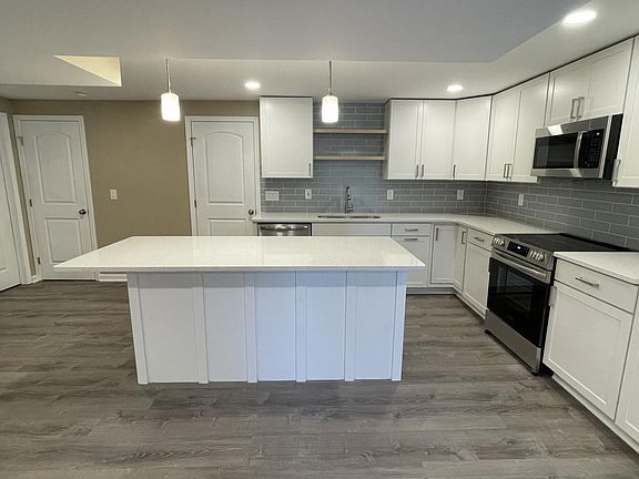 Brand new kitchen cabinets with quartz countertops and new stainless steel appliances.