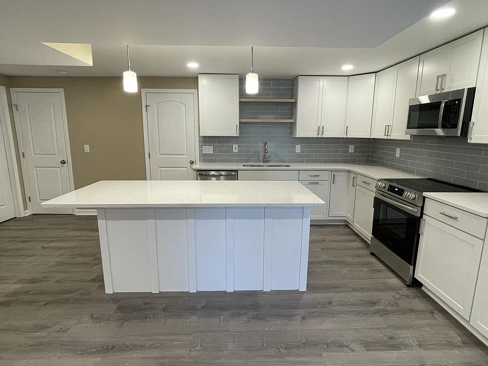 Brand new kitchen cabinets with quartz countertops and new stainless steel appliances.