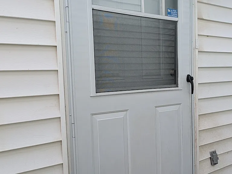 Secure side entry with updated storm door and exterior lighting for added safety and convenience.