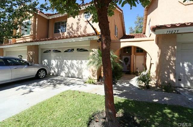 Front of house showing 2 car garage w/driveway and grass lawn.