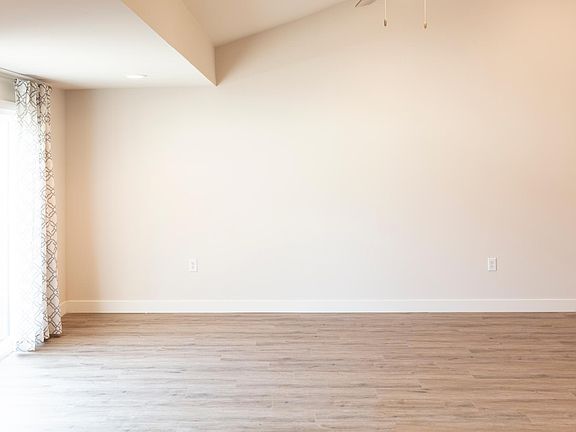 Unit 202: Large living room with ceiling fan, skylights, sliding glass door to large deck overlooking Jazz Alley.