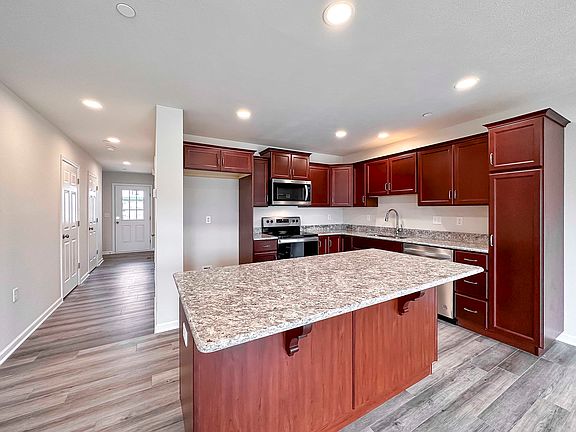 Kitchen with maple cabinetry, granite countertops and stainless steel appliances - center island and