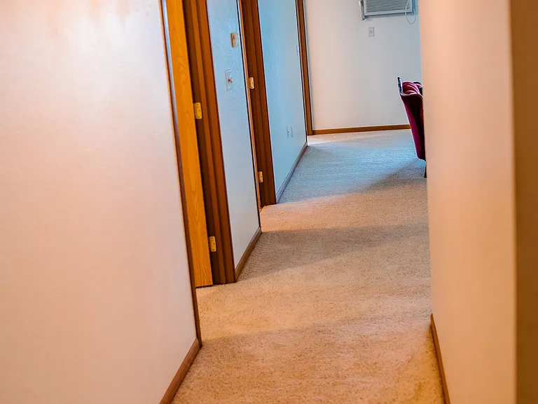 Hallway from kitchen to livingroom, with bedrooms and bath off to the left