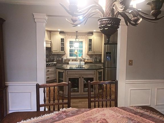 View from dining room to kitchen thru architectural pillars. Over table chandalier