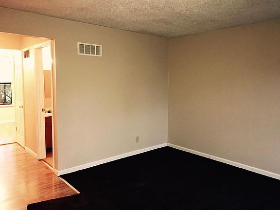 Living room with carpet and hardwood floor hallway. Half Bathroom to the right.