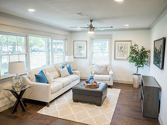 pacious living room. Ample windows let in the light and show off the wood floors.