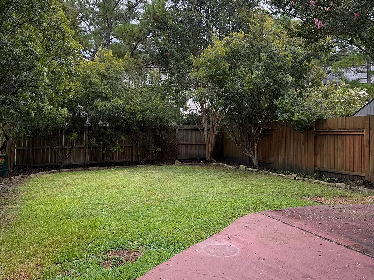Landscaped backyard with mature trees for privacy