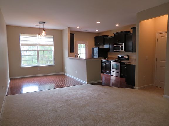 Perfect open floor plan for entertaining! Great Room w carpet & ceiling light; Dining & kitchen w wood floor, 36" espresso cabinets, can lights; door to back yard; Pantry & Half Bath on right