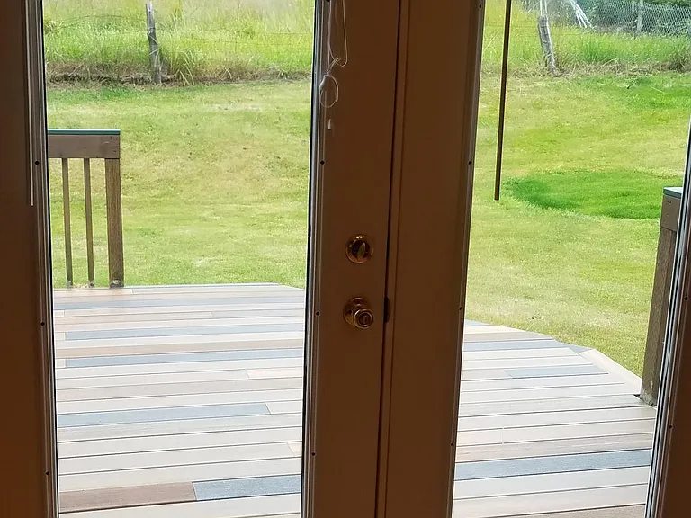 French doors open to deck and backyard