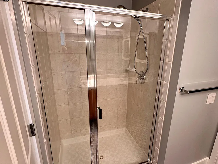 Master bathroom with two sinks, shower, and toilet