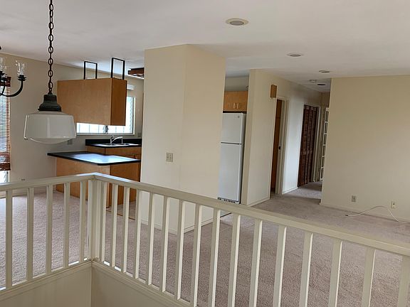 Slightly different angled view from top of stairs showing living room and hallway