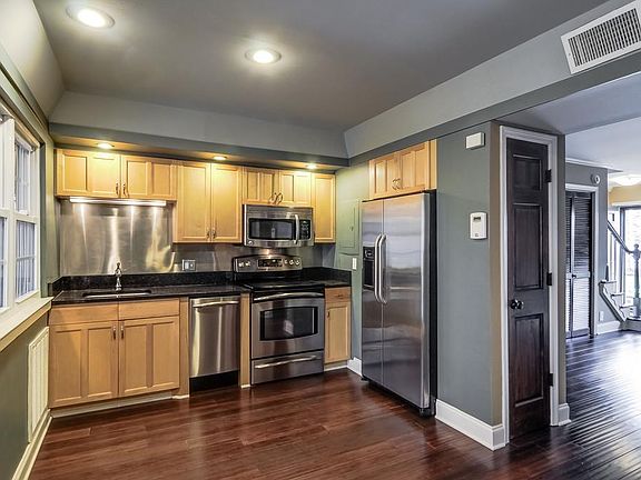 Remodeled kitchen, viewed from eating area with living area and front door in distance on right