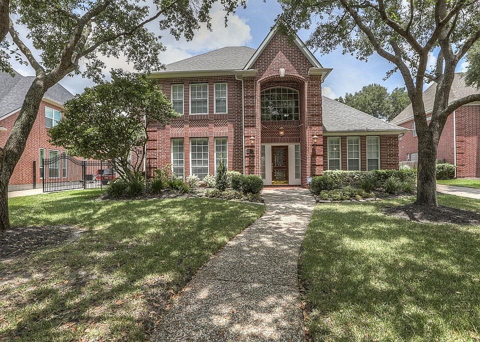 Stately custom home on a tree lined street.