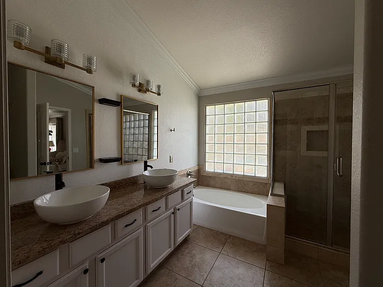 Spa-inspired primary bathroom with dual vanities, soaking tub, and separate shower.