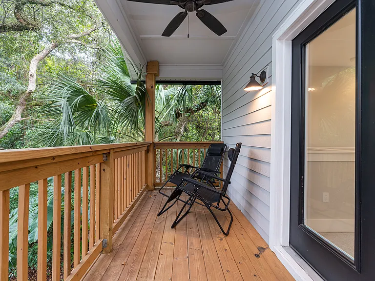 Your private treehouse escape. Enjoy serene, wooded views framed by lush tropical greenery from the comfort of this spacious upstairs deck