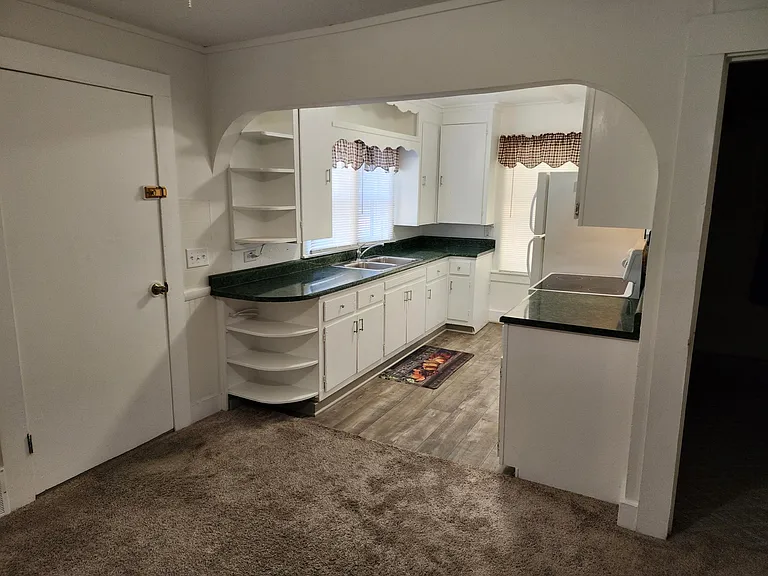 Kitchen. Door near kitchen leads to back porch containing washer/dryer hookup and furnace. Off of back porch is an exterior door leading to deck.